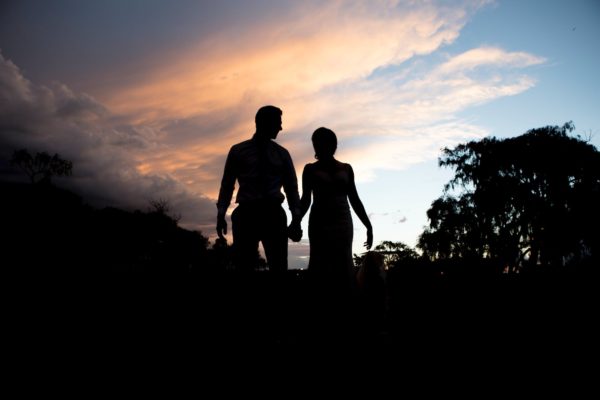 silhouette photography of woman and man standing near trees