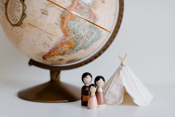 retro globe with handmade toys against gray background in room