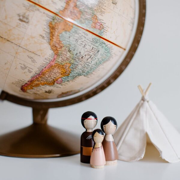 retro globe with handmade toys against gray background in room